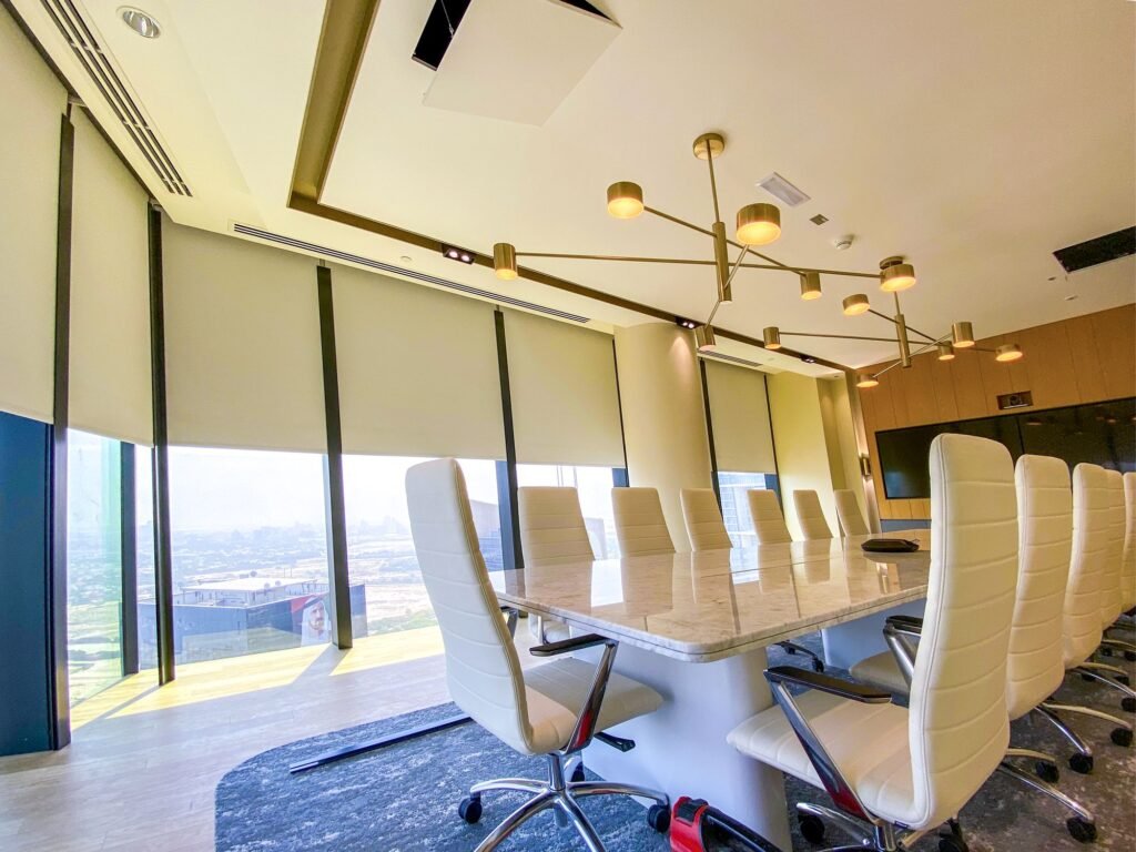 Boardroom with roller blinds part-lowered over floor-to-ceiling windows