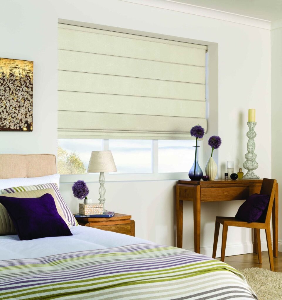 Cream Roman blind with neat folds above a bedroom window