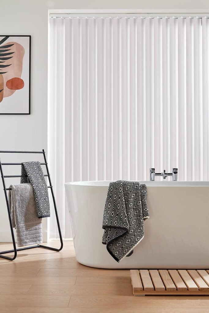 White vertical blinds behind a freestanding bath
