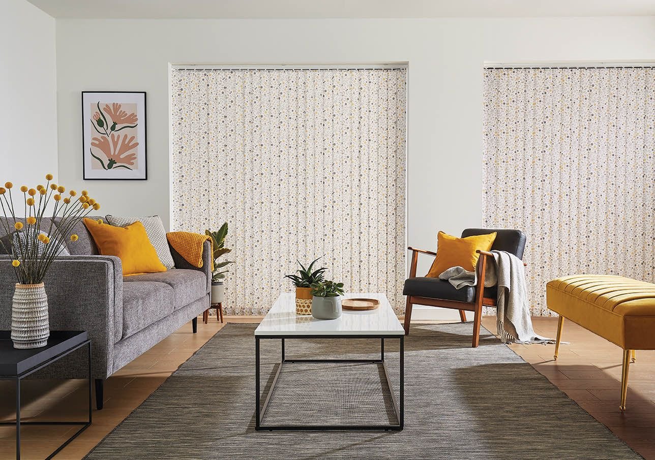 Patterned vertical blinds across two windows in a living room