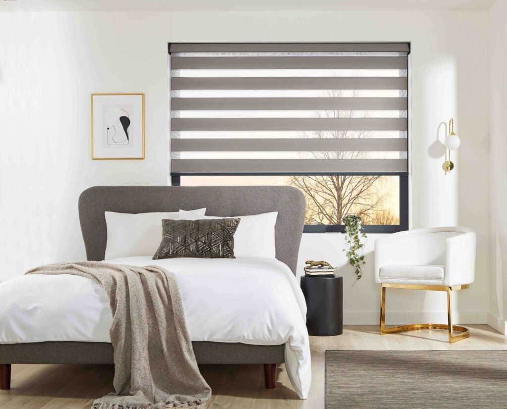 Grey vision blind above a bed with soft white linen