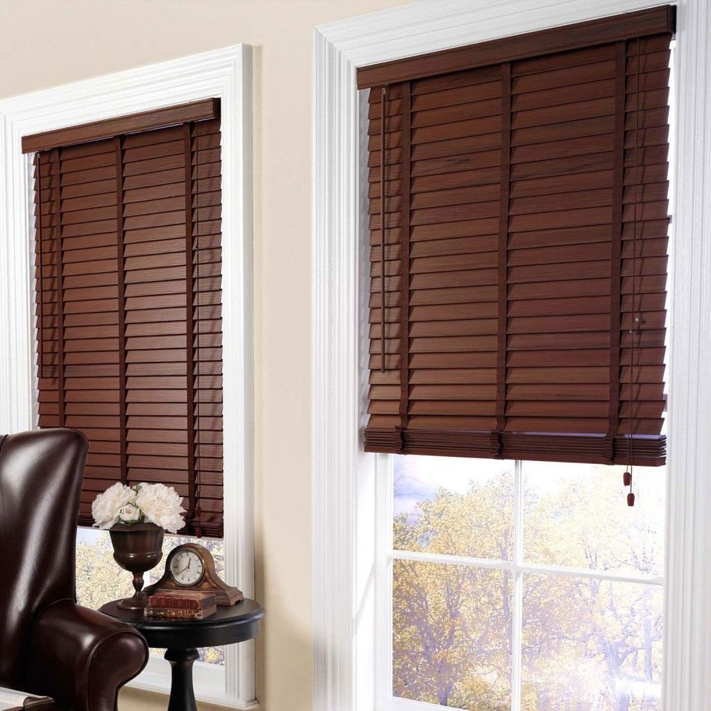 Dark-stained wooden blinds on two windows in a study