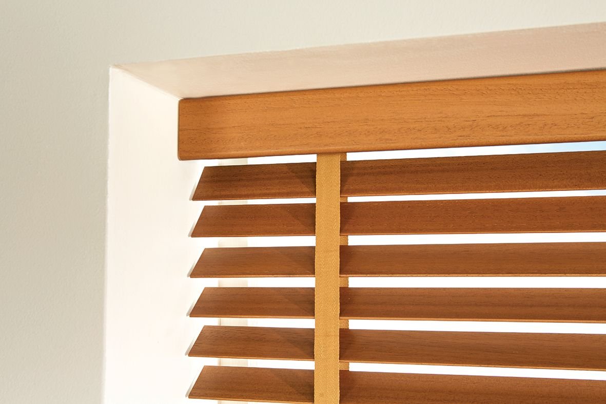 Close view of a wooden blind headrail and slats