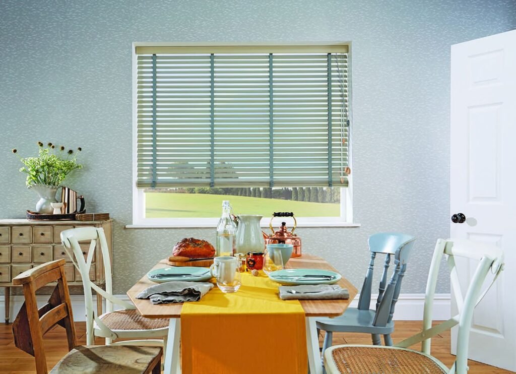 Pale wooden blind above a dining table set for a meal